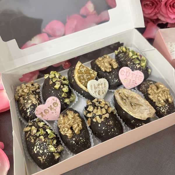 Box of chocolate-covered treats with pink heart decorations