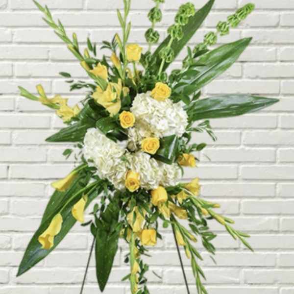 Tall floral standing spray with yellow roses and white hydrangeas