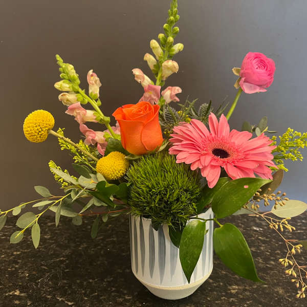 Mixed bouquet in a white vase with pink and orange blooms