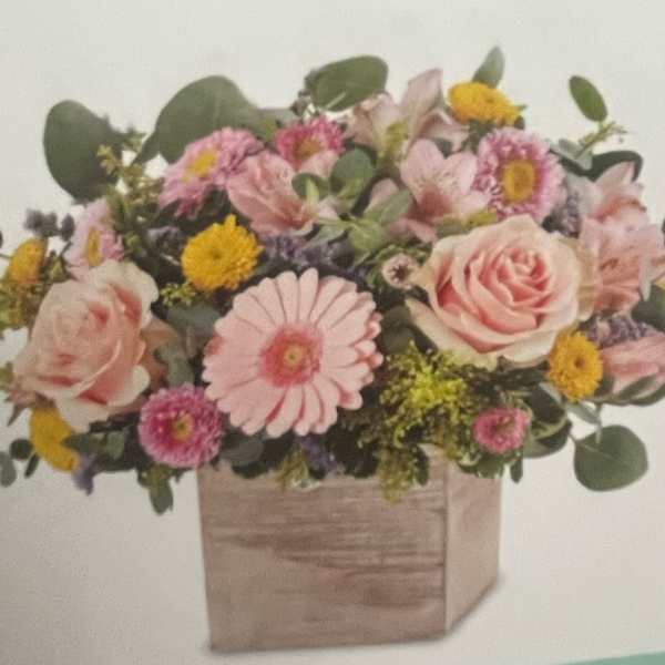 Pink and yellow mixed flower arrangement in a wooden box