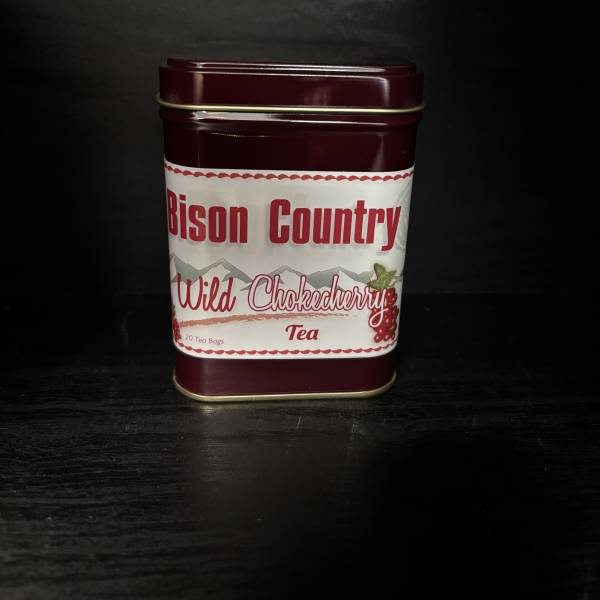 Maroon tin of Wild Chokecherry tea on a dark surface