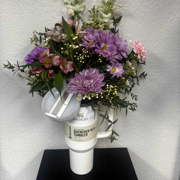 Bouquet of purple and pink flowers arranged in a white tumbler