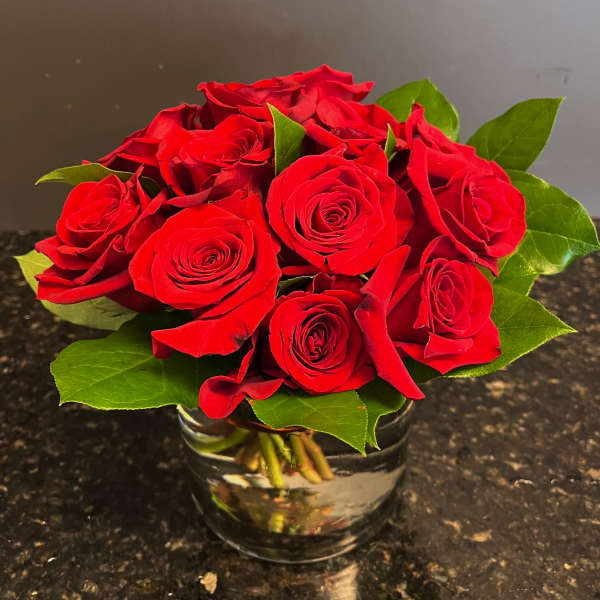 Red roses arranged in a clear glass vase