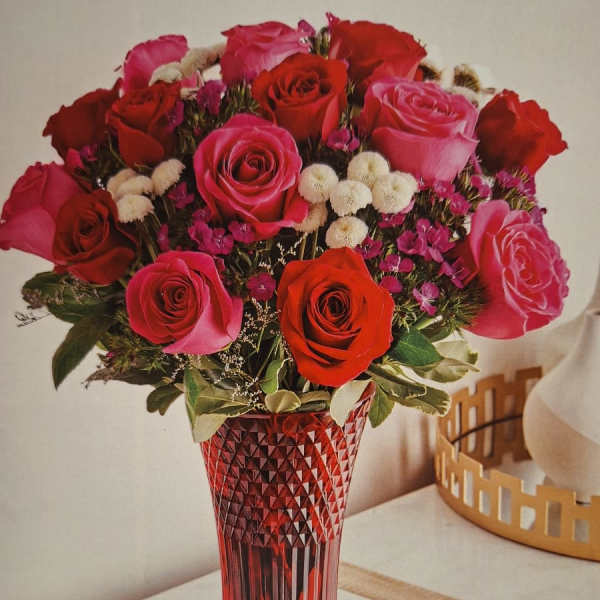 Bouquet of red and pink roses in a red glass vase
