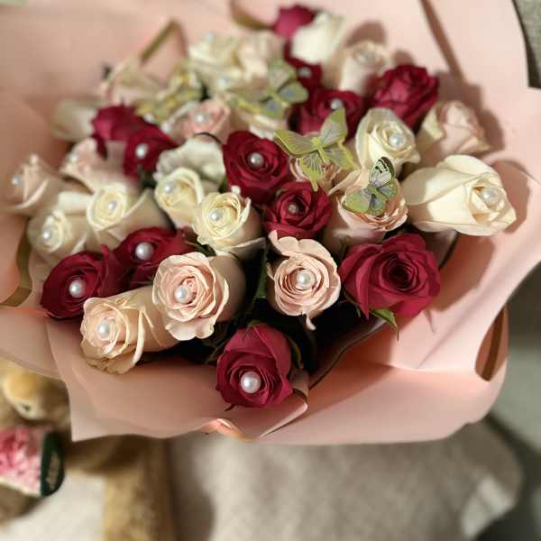 Bouquet of red and blush roses wrapped in pink paper