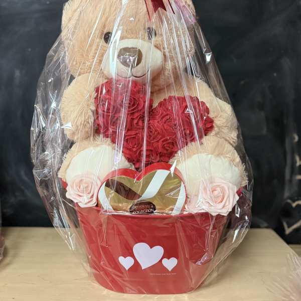 Teddy bear gift basket with red roses and chocolates in a red container