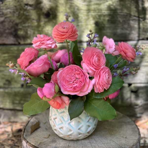 Pink ranunculus bouquet in a white textured vase