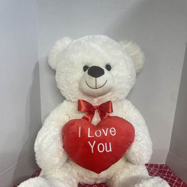 White teddy bear holding a red heart that says I Love You