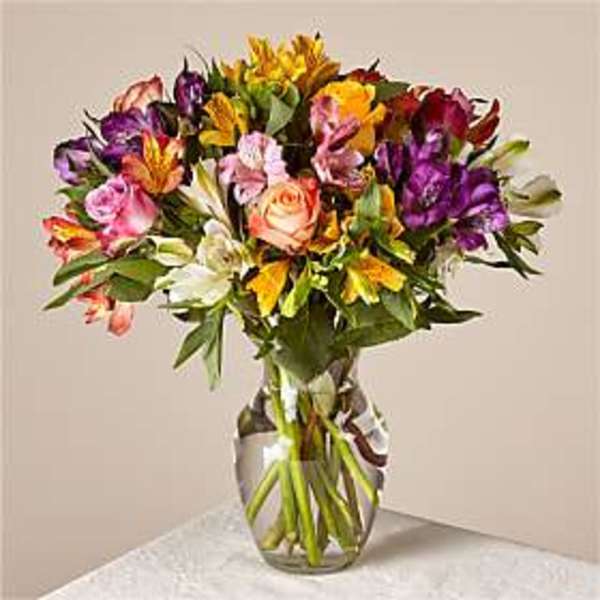 Mixed bouquet of colorful flowers in a clear glass vase
