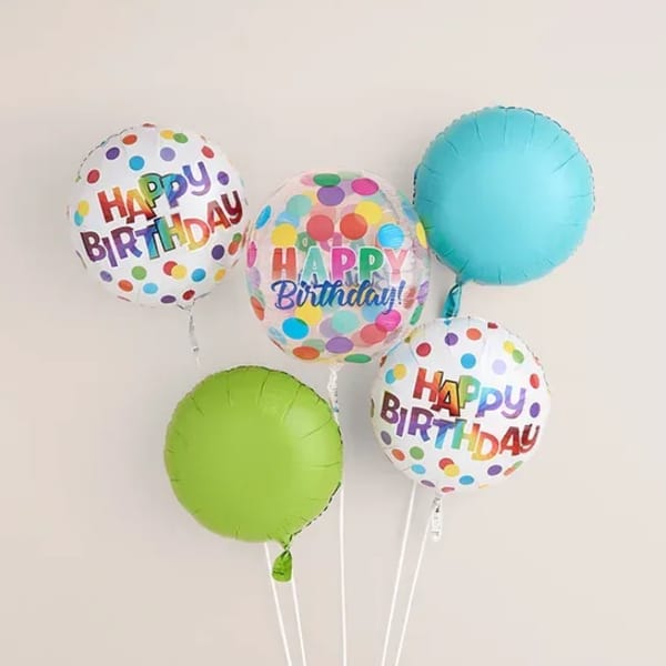 Cluster of colorful birthday balloons with polka dots and "Happy Birthday" text