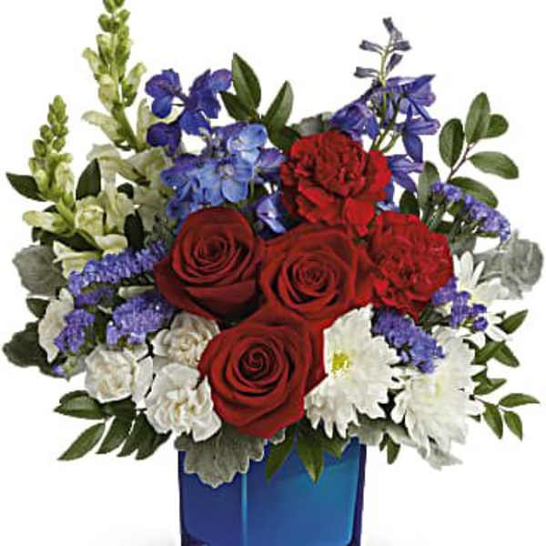 Red roses and white flowers in a blue glass vase