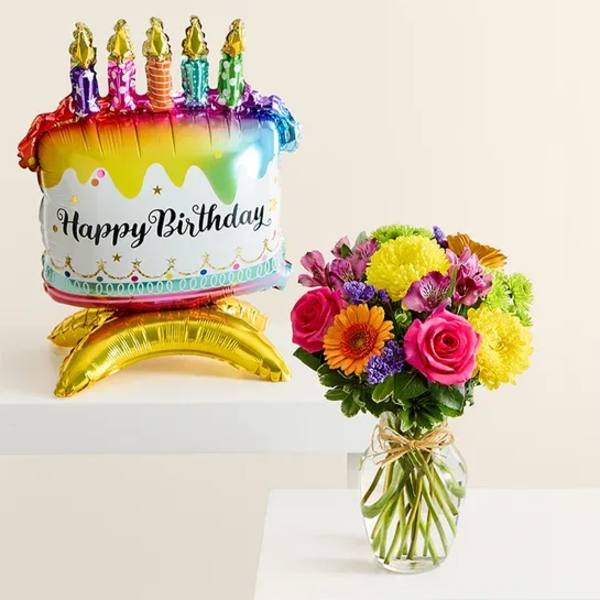 Birthday balloon with a colorful flower bouquet in a glass vase