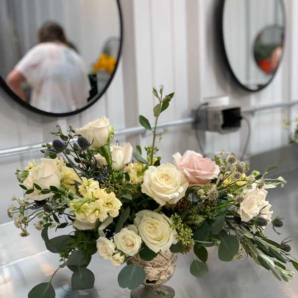 Cream and blush rose arrangement in a pedestal vase