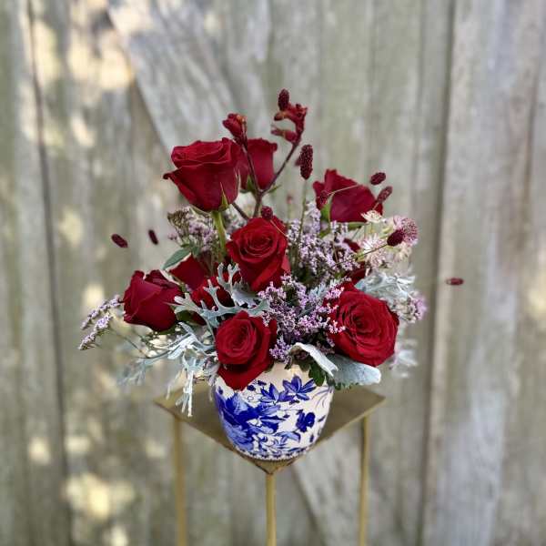 Red roses arranged in a blue-and-white ceramic vase