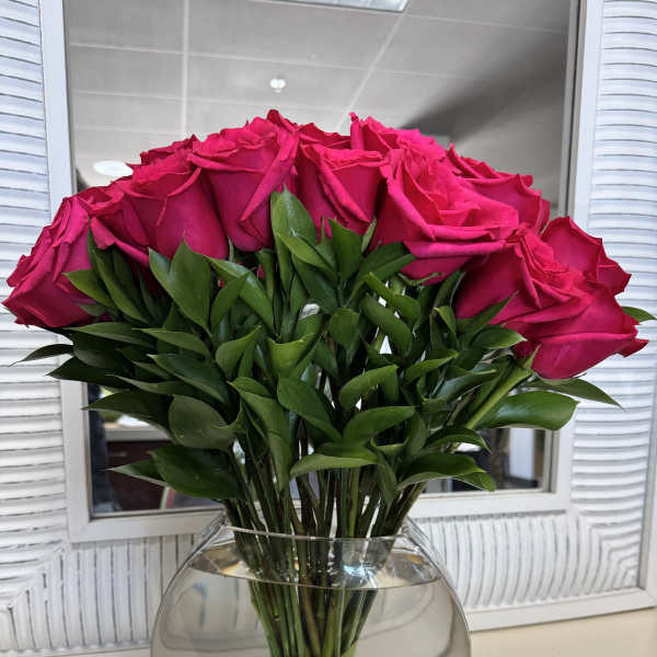 Bouquet of hot pink roses in a round glass vase
