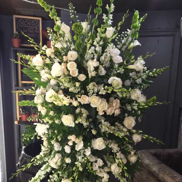 Large white floral standing spray with roses and snapdragons
