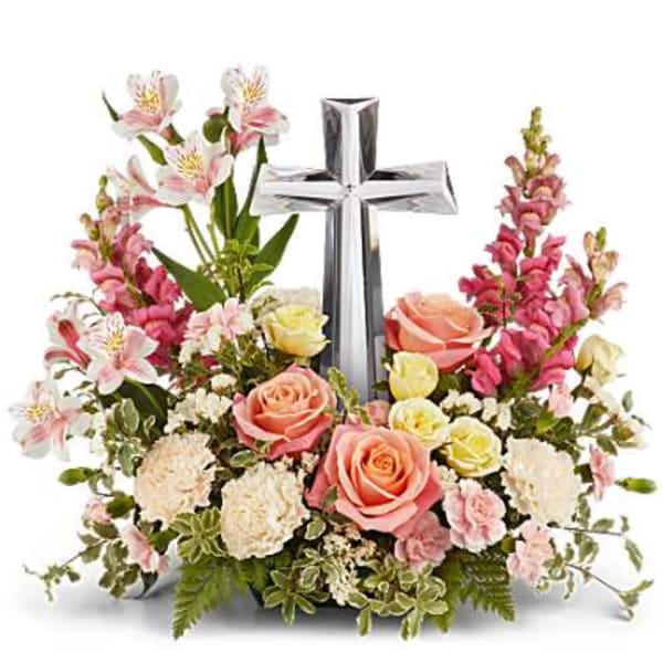 Floral arrangement with a silver cross and pink roses