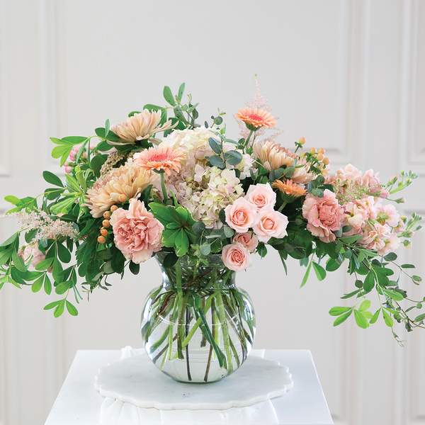 Peach and pink floral arrangement in a clear glass vase