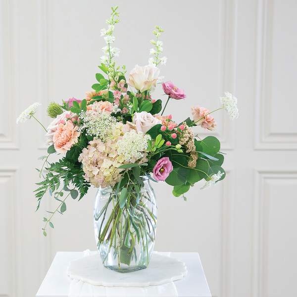Pastel mixed flower arrangement in a clear glass vase