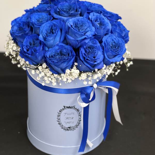 Blue rose bouquet in a round hat box with white baby's breath and ribbon