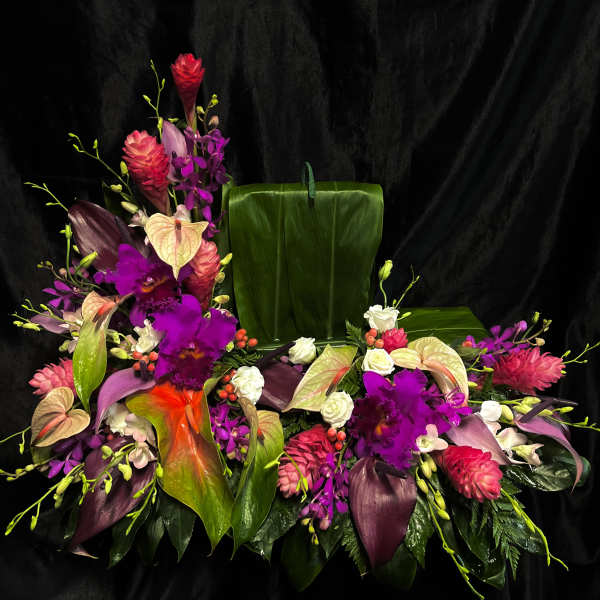 Tropical floral arrangement with purple orchids, anthuriums, and pink blooms