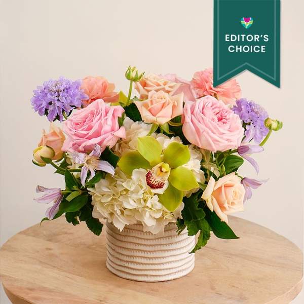 Pastel flower arrangement in a ribbed white vase