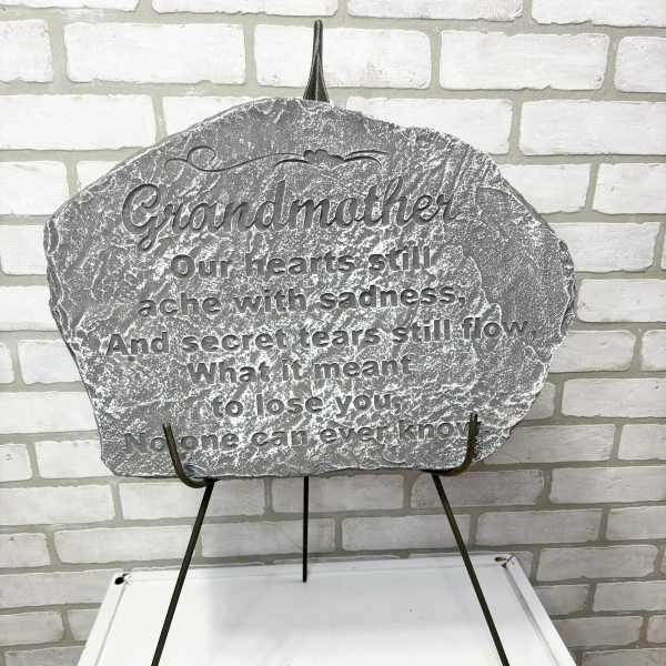 Gray memorial plaque on a metal stand with engraved text