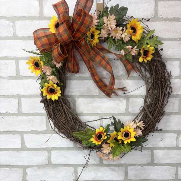 Floral wreath with sunflowers, pale daisies, and a plaid bow