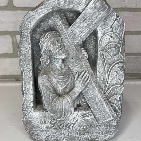 Stone religious plaque of Jesus carrying a cross