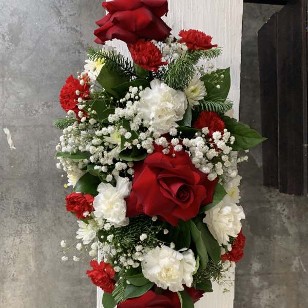 Red and white floral arrangement with roses, carnations, and baby's breath