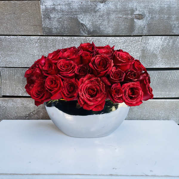 Red roses arranged in a silver bowl vase