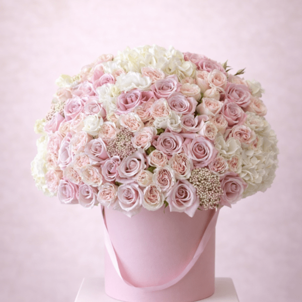 Pink and white roses arranged in a round hatbox