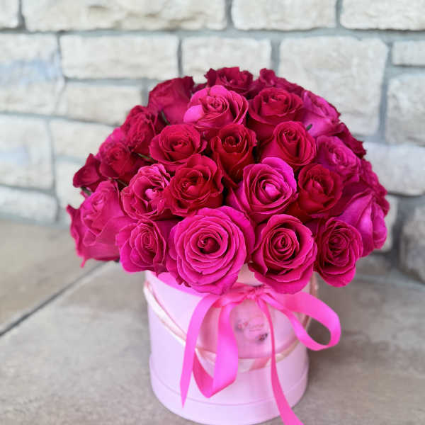 Bouquet of hot pink roses in a pink hat box with ribbon