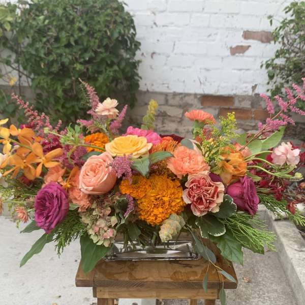 Colorful mixed flower arrangement in a low rectangular vase