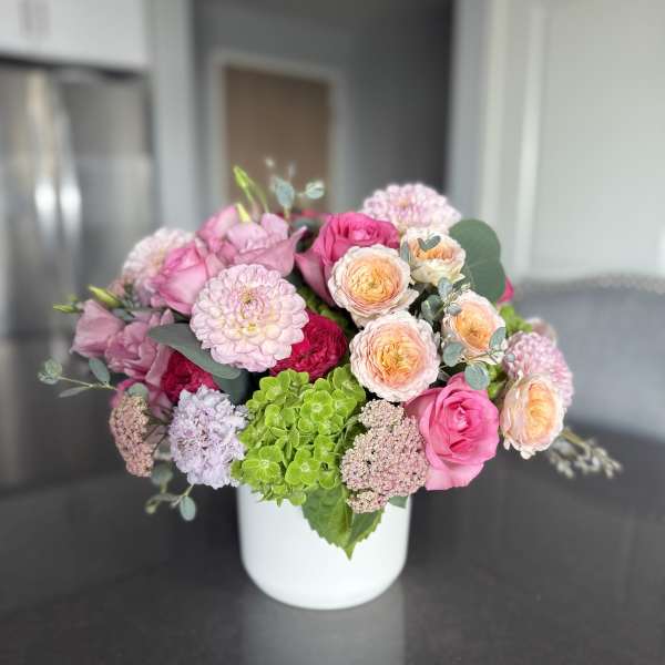 Pink and peach mixed bouquet in a white vase