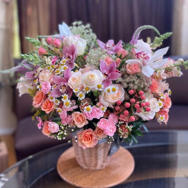 Pink and peach mixed bouquet in a woven basket