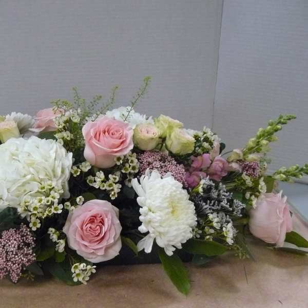 Low floral centerpiece with pink roses, white hydrangeas, and white chrysanthemums