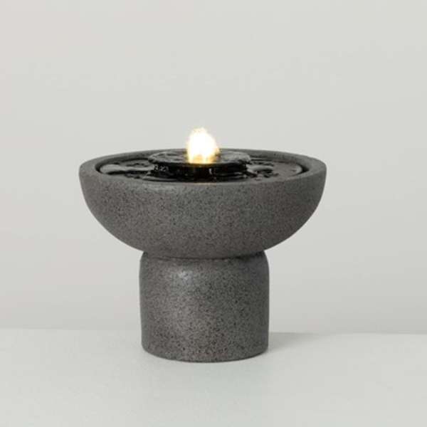 Gray tabletop fountain with a small flame in the center