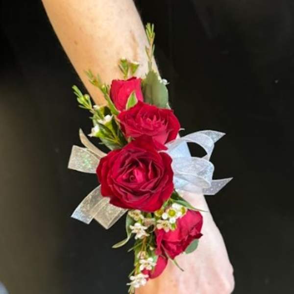 Red rose wrist corsage with ribbon on a wrist