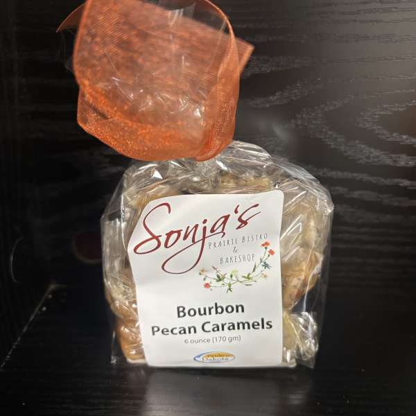 Bag of bourbon pecan caramels tied with orange ribbon