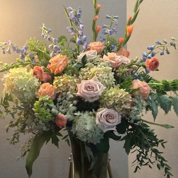 Tall mixed bouquet in a glass vase with lavender and peach flowers