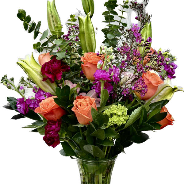Bouquet of orange roses, purple flowers, and lilies in a glass vase