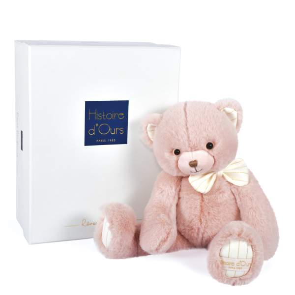 Pink teddy bear beside a white gift box