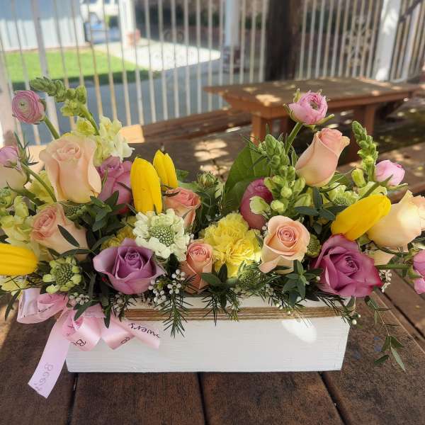 Mixed bouquet of roses and yellow tulips in a white box