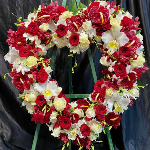 Heart-shaped floral wreath with red and white roses and orchids
