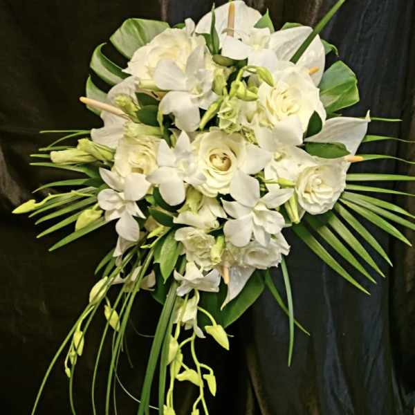 White floral bouquet with roses and orchids on a dark background