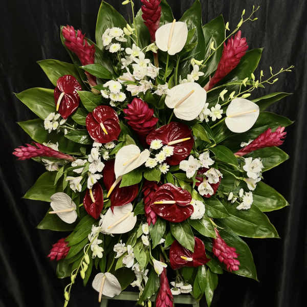 Large red, white, and pink floral standing spray on an easel