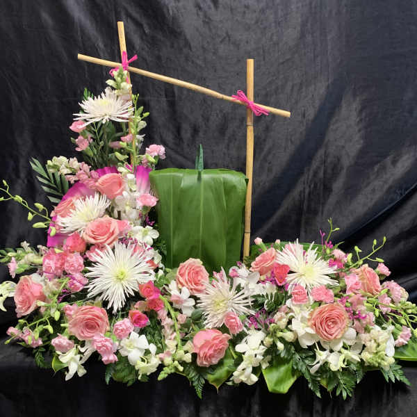 Pink roses and white spider mums arranged around a green leaf panel.