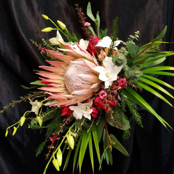 Large tropical bouquet with a protea, white lilies, and red blooms
