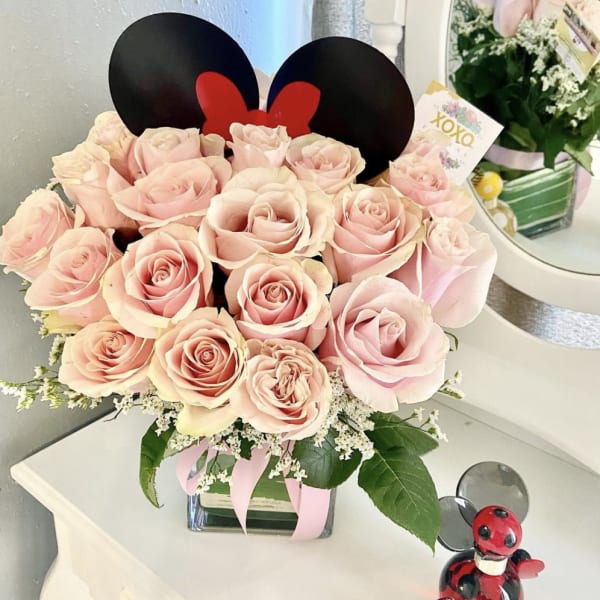 Pink roses in a square glass vase with Mickey ears topper